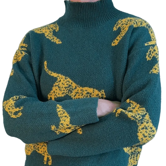 Green sweater with yellow animal patterns on a plain background