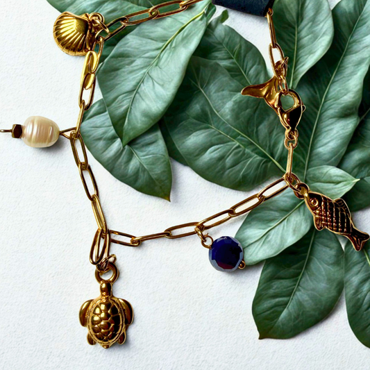 Armband - krale en goudkleur charms