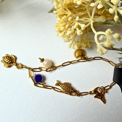 Armband - krale en goudkleur charms