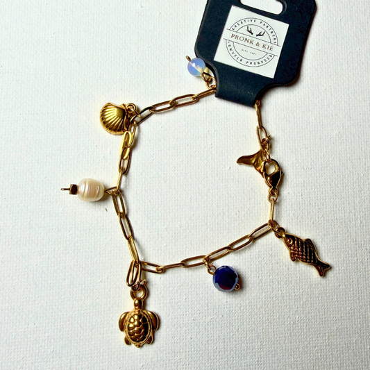Armband - krale en goudkleur charms