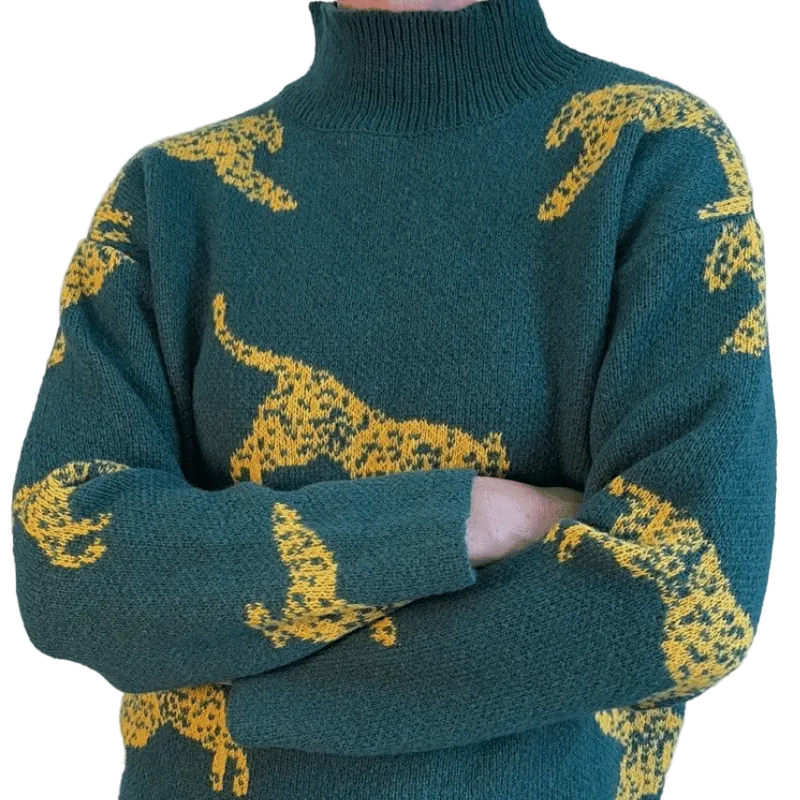 Green sweater with yellow animal patterns on a plain background