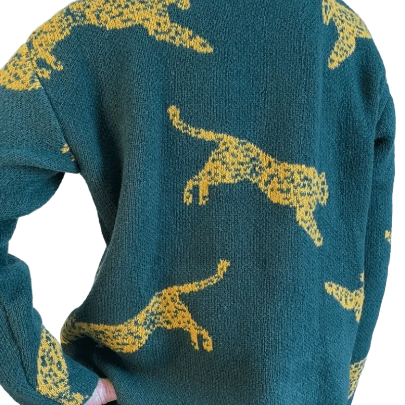 Green sweater with yellow animal patterns on a white background