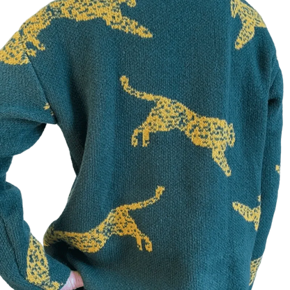 Green sweater with yellow animal patterns on a white background