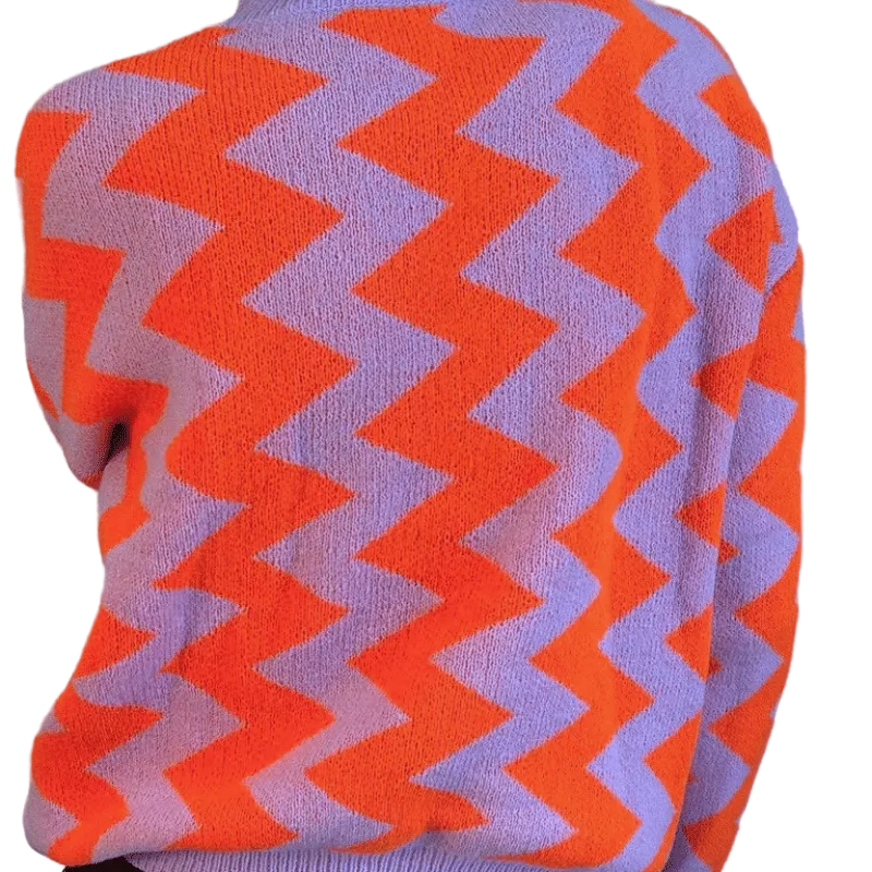 Close-up of a sweater with orange and purple zigzag pattern on a gray background